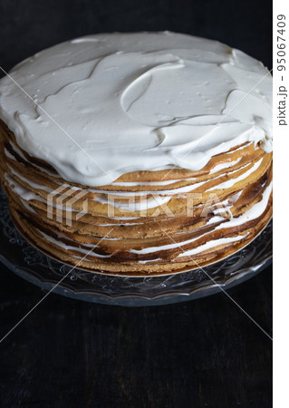 a whole round honey cake on a stand against a dark background a whole round honey cake on a stand against a dark background 95067409
