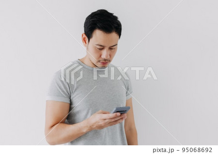 Asian man concentrated on smartphone isolated on white background. 95068692
