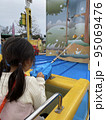 遊園地で一生懸命ゲームをしている女の子 95069476
