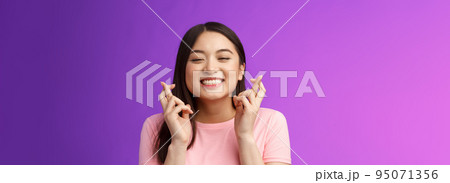 Headshot dreamy lucky cute asian girl believe she win, make wish, cross fingers good fortune, close eyes smiling happily feeling hopeful receive positive results, stand purple background Headshot dreamy lucky cute asian girl believe she win, make wish, cross fingers good fortune, close eyes smiling happily feeling hopeful receive positive results, stand purple background 95071356