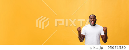 Handsome young Afro-American man employee feeling excited, gesturing actively, keeping fists clenched, exclaiming joyfully with mouth wide opened, happy with good luck or promotion at work 95071580