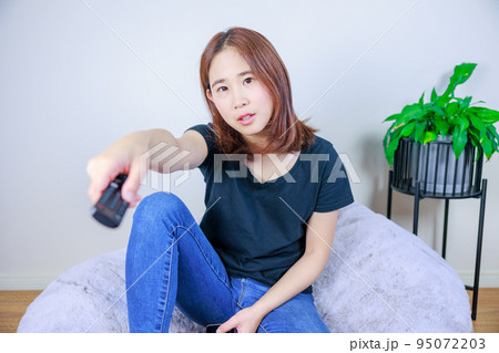 リモコンを操作する女性 95072203