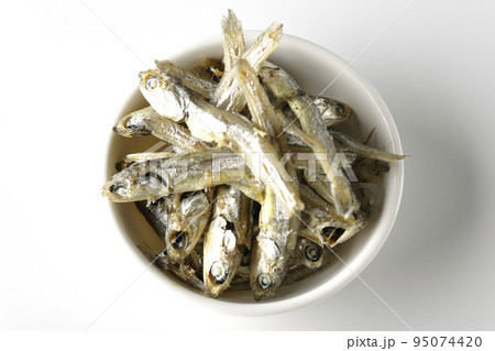 小皿に盛られた片口いわしの煮干しを白背景で俯瞰撮影 95074420