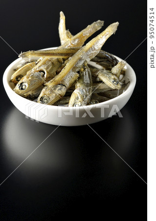 小皿に盛られた片口いわしの煮干しを黒背景で撮影 95074514