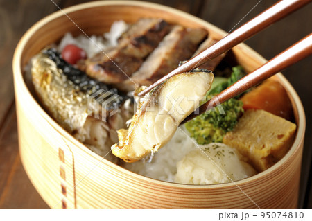 豚肉やポテサラ、玉子焼き等が曲げわっぱに入っている焼き魚弁当の鯖の塩焼きを食べる 95074810
