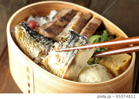 豚肉やポテサラ、玉子焼き等が曲げわっぱに入っている焼き魚弁当の鯖の塩焼きを食べる 95074812