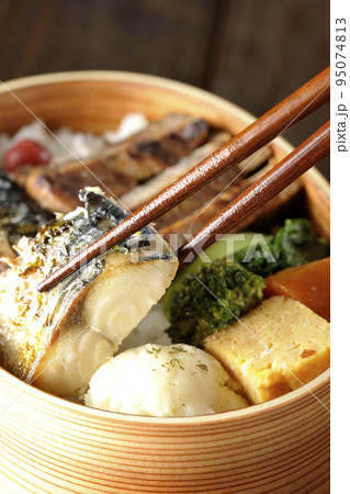 豚肉やポテサラ、玉子焼き等が曲げわっぱに入っている焼き魚弁当の鯖の塩焼きを食べる 豚肉やポテサラ、玉子焼き等が曲げわっぱに入っている焼き魚弁当の鯖の塩焼きを食べる 95074813