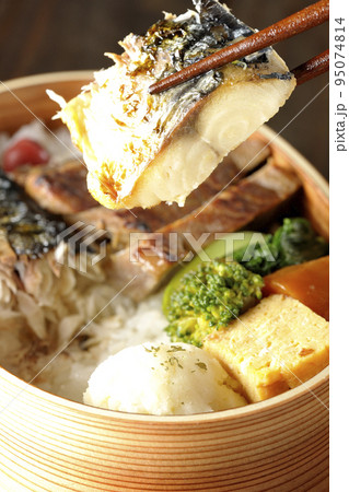 豚肉やポテサラ、玉子焼き等が曲げわっぱに入っている焼き魚弁当の鯖の塩焼きを食べる 95074814