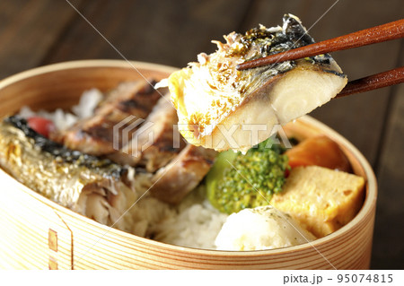 豚肉やポテサラ、玉子焼き等が曲げわっぱに入っている焼き魚弁当の鯖の塩焼きを食べる 豚肉やポテサラ、玉子焼き等が曲げわっぱに入っている焼き魚弁当の鯖の塩焼きを食べる 95074815