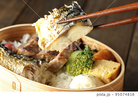 豚肉やポテサラ、玉子焼き等が曲げわっぱに入っている焼き魚弁当の鯖の塩焼きを食べる 豚肉やポテサラ、玉子焼き等が曲げわっぱに入っている焼き魚弁当の鯖の塩焼きを食べる 95074816