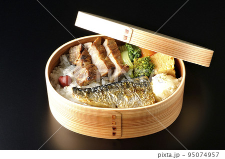 豚肉やポテサラ、玉子焼き等が曲げわっぱに入っている焼き魚弁当を黒背景で撮影 豚肉やポテサラ、玉子焼き等が曲げわっぱに入っている焼き魚弁当を黒背景で撮影 95074957