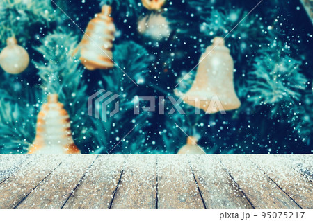 Wood table with snow and Decorated golden bells on Christmas tree Wood table with snow and Decorated golden bells on Christmas tree 95075217