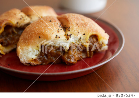 具がたっぷり包まれた焼きカレーパン 95075247