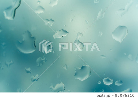 Water drops on glass against blue sky, rainy season concept. Window view background screensaver Water drops on glass against blue sky, rainy season concept. Window view background screensaver 95076310