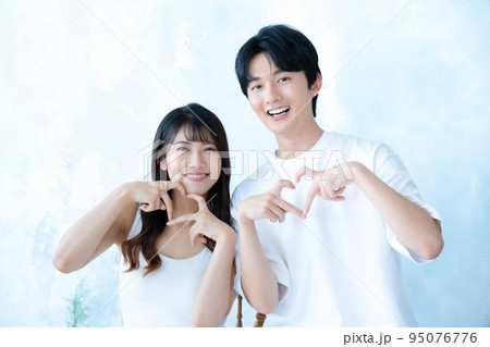 ハートポーズをする若いカップル 95076776