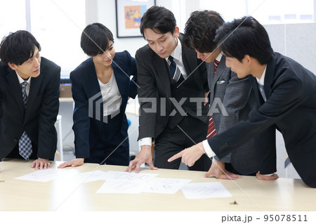 デザイン案を見比べて話し合うビジネスパーソン5人_5 95078511