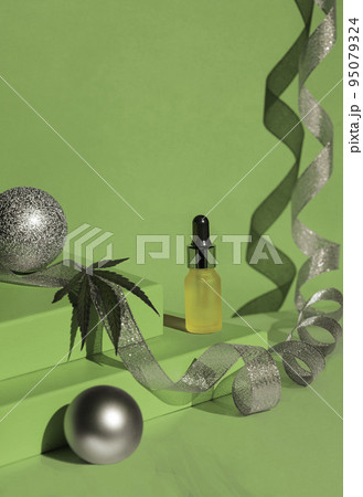 green podium of gift boxes golden ribbon. Christmas background with podium for cannabis products. cbd oil. Silver ribbon and balls 95079324