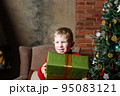 Happy caucasian boy holding present in hand. 95083121