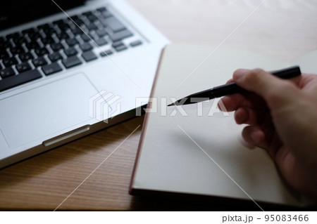 ノートPCとノートにメモをする男性の手元イメージの写真素材 [95083466 ...