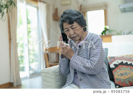 心配そうに電話をするシニア女性 心配そうに電話をするシニア女性 95083756