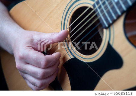 The musician plays the acoustic guitar. 95085113