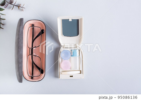 Glasses in a case and a set for contact lenses on a blue. Choice of vision correction method. 95086136