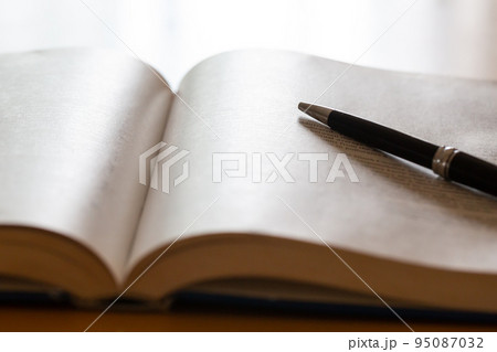 机の上に開いた英語の書籍とペン 研究 学習のイメージ 95087032