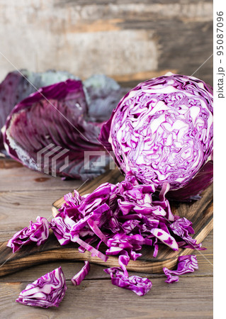 Sliced head of red cabbage on a cutting board on a wooden table. Close-up. Vertical view Sliced head of red cabbage on a cutting board on a wooden table. Close-up. Vertical view 95087096