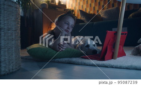 Young girl watching movies with dog Young girl watching movies with dog 95087239