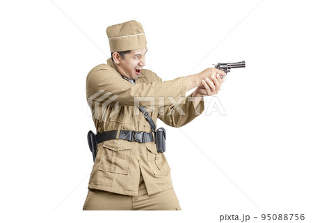 Indonesian freedom fighter standing while holding gun Indonesian freedom fighter standing while holding gun 95088756