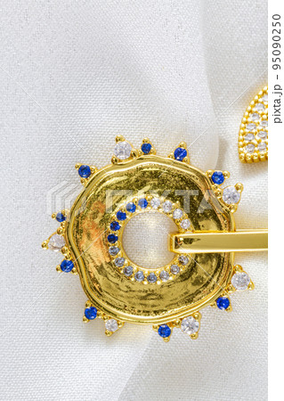 Necklace with protection symbol shape and sapphire gem close-up on white Necklace with protection symbol shape and sapphire gem close-up on white 95090250