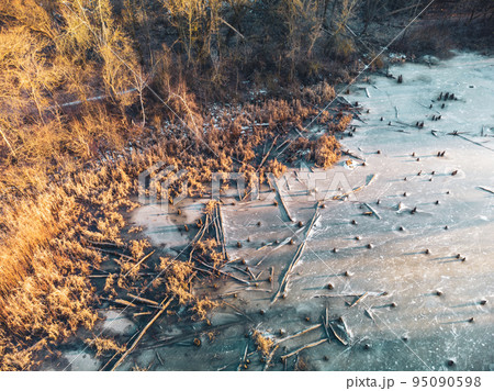 Aerial view on frozen wild lake in sunset forest Aerial view on frozen wild lake in sunset forest 95090598
