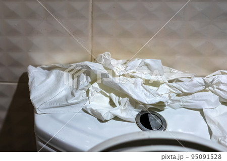 Many of soft toilet paper on top of commode reservoir lid in bathroom. A lot of hygienic paper on flush tank was torn up and prepared to clean up after feces were done. Many tissues on flush toilet. Many of soft toilet paper on top of commode reservoir lid in bathroom. A lot of hygienic paper on flush tank was torn up and prepared to clean up after feces were done. Many tissues on flush toilet. 95091528