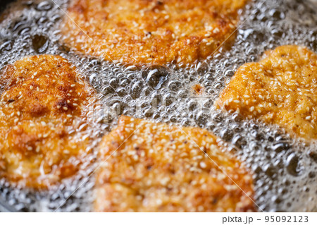 Detail of bubbles in frying oil as schnitzels fry in the pan Detail of bubbles in frying oil as schnitzels fry in the pan 95092123