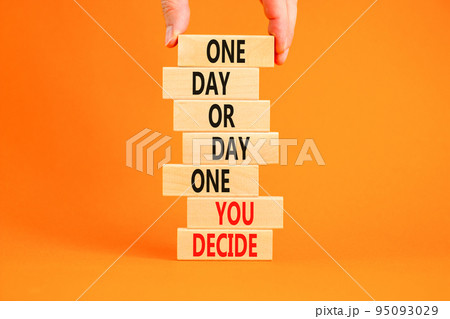 Day one symbol. Concept words One day or day one you decide on wooden blocks on a beautiful orange table orange background. Businessman hand. Business motivational and day one concept. 95093029