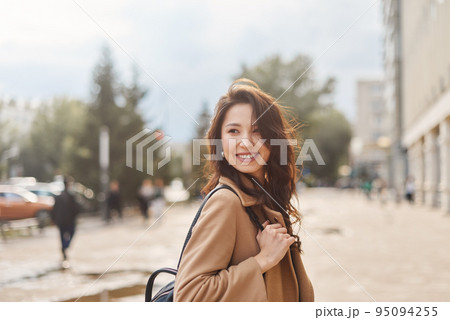 Lifestyle portrait pretty Asian kazakh woman with brilliant smile on street Lifestyle portrait pretty Asian kazakh woman with brilliant smile on street 95094255