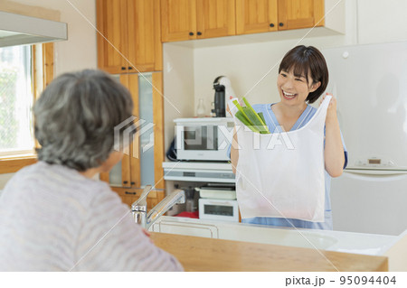 買い物代行をする女性介護士と利用者の女性 95094404