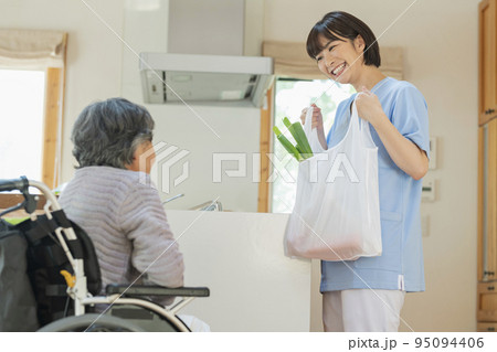 買い物代行をする女性介護士と利用者の女性 95094406
