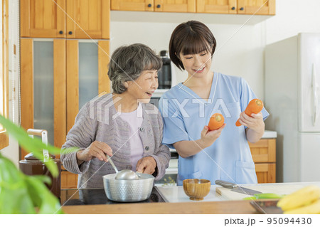 利用者と食事を作る女性介護士 利用者と食事を作る女性介護士 95094430