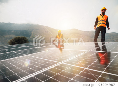 Workers assemble energy system with solar panel for electricity 95094987