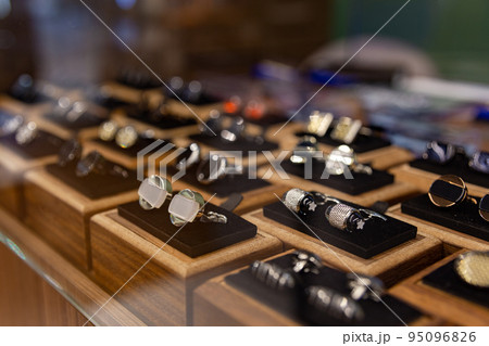 Boxes with cufflinks on shelf in boutique. 95096826