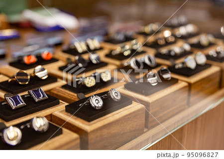 Boxes with cufflinks on shelf in boutique. 95096827