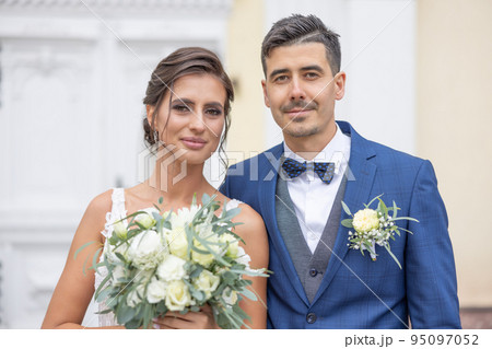 Beautiful young newlyweds smiling to the camera shortly after getting married 95097052