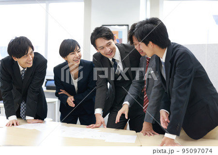 笑顔でデザイン案の意見を交わすビジネスパーソン5人_5 95097074