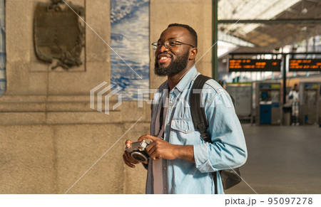 Smiling black tourist man at portuguese train station Smiling black tourist man at portuguese train station 95097278