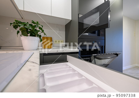 Marble worktop of modern white and dark grey kitchen 95097338