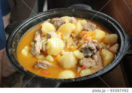 stewed potatoes with vegetables and shurpa meat in a close-up cauldron. Homemade food. Food in nature. delicious national dish 95097492