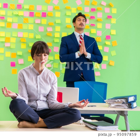 Man and woman in the office with many conflicting priorities in 95097859