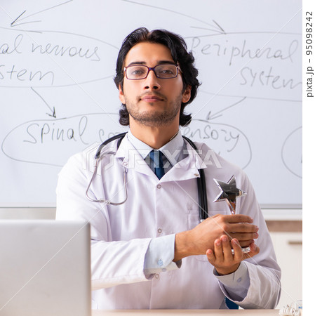 Young male doctor neurologist in front of whiteboard Young male doctor neurologist in front of whiteboard 95098242