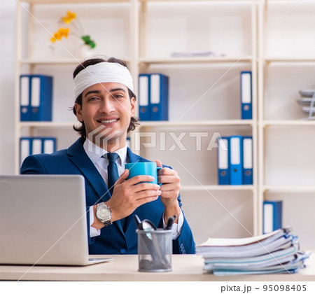 Head injured male employee working in the office 95098405